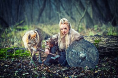 Saldırmak için - kadın savaşçı Film Tema açık Kuzey savaşçı kadını kalkan ve balta onun hazır yanında kurt ile tutarak örgülü saç ve savaş makyaj ile viking ormandaki - sinema ve film filtresi