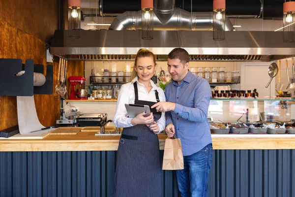 Küçük işletme sahibi iki küçük aile restoranı online sipariş için tablet Restoran gıda teslim ile çalışan genç girişimciler ile aile şirketi kavramı bakarak içinde