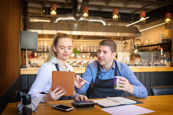 Genç adam ve kadın evrak işi birlikte onların Restoran geçmekte. Küçük aile Restoran sahipleri finans faturaları ve kendi küçük işletme giderleri hesaplama tartışıyor.