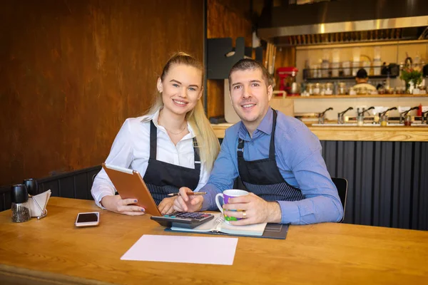 Mutlu bir adam ve kadın evrak işi birlikte onların Restoran geçmekte. Küçük aile restoran sahipleri Finans faturaları ve kendi küçük işletme giderleri hesaplama tartışıyor.