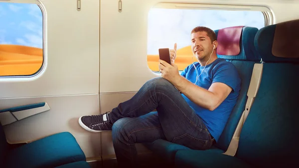 Happy middle aged man sharing content on streaming platform by smart phone - Millenial tourist having fun vlogging live feeds on social media network while traveling by train to discover world deserts