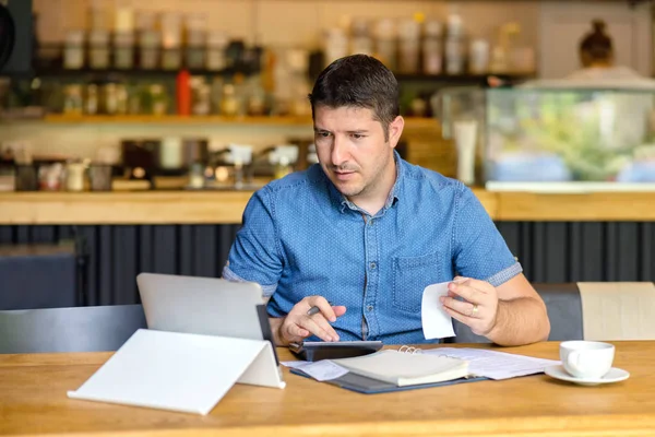 Olgun küçük işletme sahibi faaliyet mali faturaları hesaplama, Girişimci çalışmak ve hesaplamak ve yeni iş start-up finansal giderleri analiz dizüstü bilgisayar ve hesap makinesi kullanarak