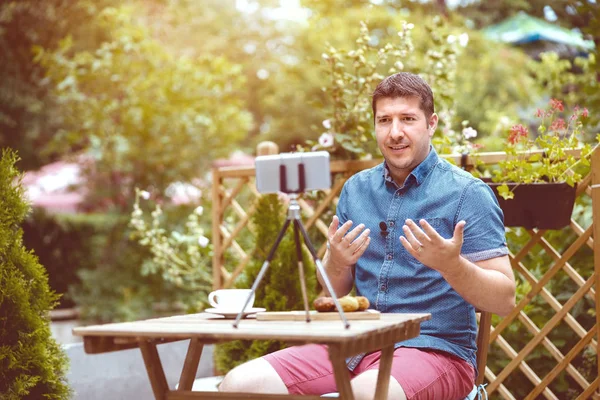 Man vlogger besleme vlog için video kaydederken akıllı telefon kullanarak - Dijital göçebe seyahat ederken online içerik paylaşımı - Gündelik iş adamı blog ile yeni dijital iş trendi ve teknoloji konsepti