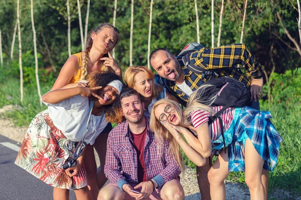Komik yüzlerle selfie çeken çok ırklı bin yıllık arkadaşlar - Seyahat macerası olan mutlu gençler birlikte eğleniyor - ırkçılığa karşı arkadaşlık konsepti ile insanların bağ kurması ve anlarını paylaşma