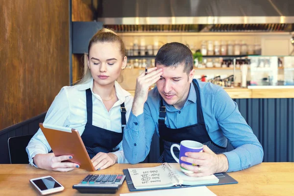 Olgun yeni küçük işletme sahipleri online restoran faturaları ve vergileri hesaplıyorlar.