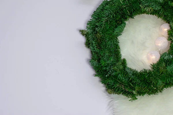 White, green background with spruce wreath, baubles, rug, blanket