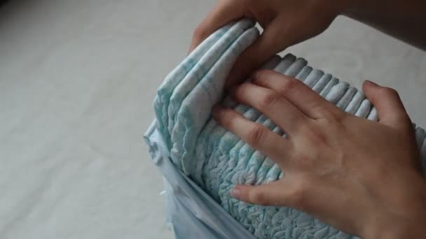 Девушка вынимает подгузники из упаковки, крупным планом — стоковое видео