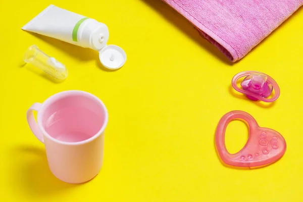 歯とパスタ、子供用グッズ、タオル、歯磨き粉、黄色の背景の上にカップを洗浄用ブラシ — ストック写真