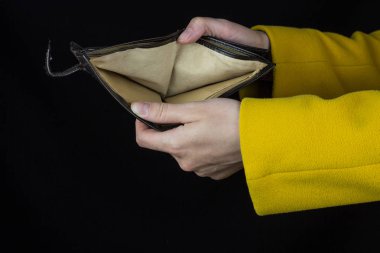 Kız boş bir çanta siyah bir arka plan üzerinde tutarak yakın çekim