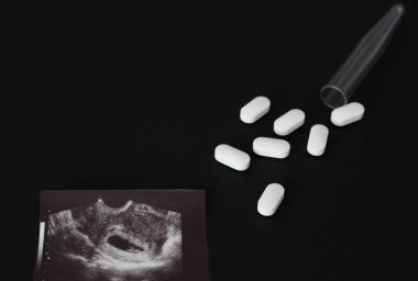 Uzi vurdu, hap ve tüp bir siyah arka plan, kürtaj, yakın çekim