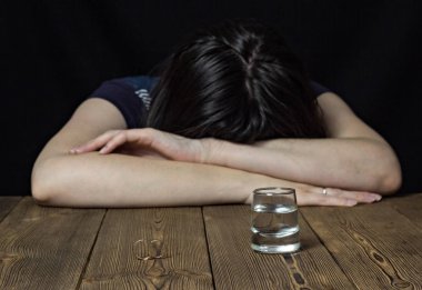 Sarhoş kız ve alkol ahşap arka plan, Alyans bir tablo üzerinde Evlilik boşanma