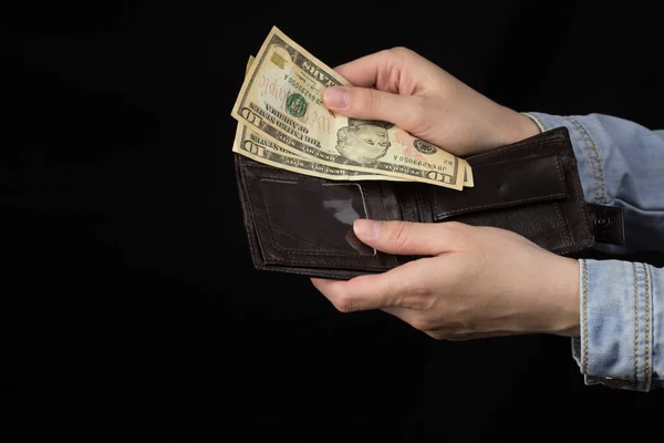 Kobiece ręce trzymając dolarów z torba na czarnym tle, zbliżenie — Zdjęcie stockowe