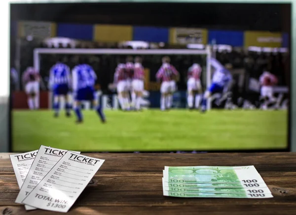 On the TV there is a league of champions on football on a table bookmaker\'s tickets and euro, rates on sports