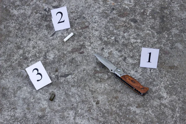 Cuchillo plegable, colilla de cigarrillo y manga de la pistola, en el suelo de hormigón, investigación y pruebas —  Fotos de Stock