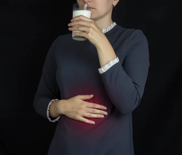 Het meisje houdt vast aan de maag en drinken melk, pijn en branden in de maag, zuurbranden — Stockfoto
