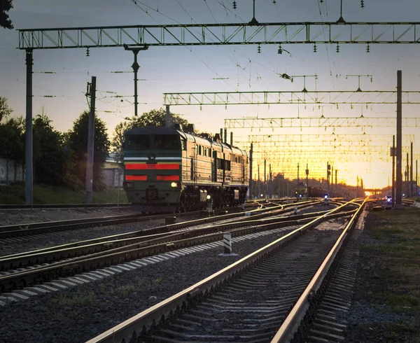 Comboio sem vagões, locomotiva ao pôr-do-sol, caminho de ferro e sol — Fotografia de Stock