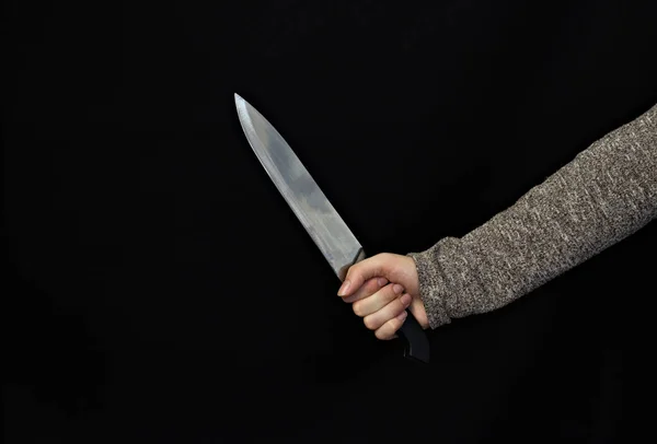 Tangan seorang gadis dengan pisau di latar belakang hitam, close-up — Stok Foto