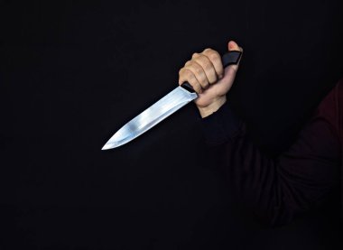Adamın elinde bir bıçak, siyah arka plan, yakın çekim, tehlike ile