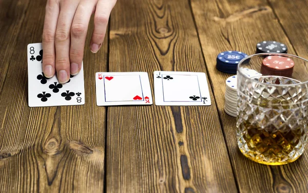 Fichas de póker mano alcohol tarjeta, fondo de madera —  Fotos de Stock