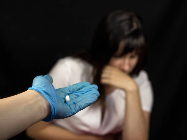 手袋に医者は頑張る女の子錠剤は、気分が悪い、黒い背景医療用手袋 — ストック写真