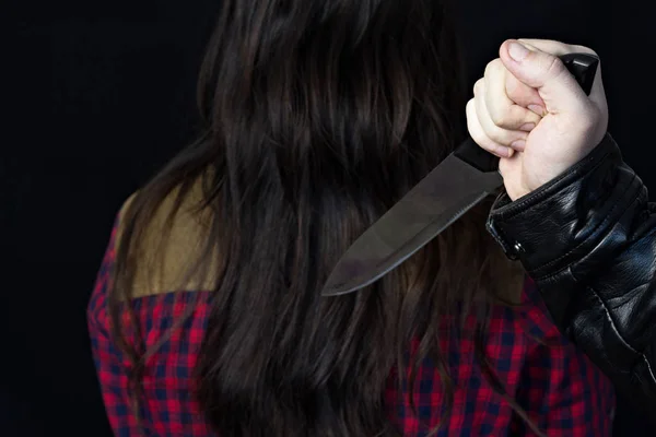 Férfi kézzel kés, a lány a háttérben, a közeli, fekete háttér, a veszély — Stock Fotó