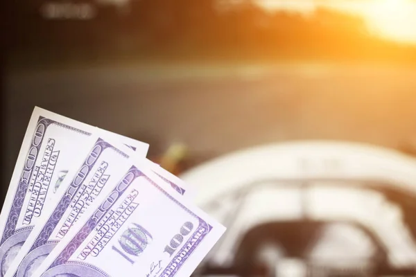 Pieniądze dolarów na tle telewizor na którym przejdź auto wyścigi Formuły 1, zachód słońca, z bliska — Zdjęcie stockowe