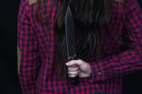 Gadis memegang pisau di belakangnya, latar belakang hitam, close-up — Stok Foto