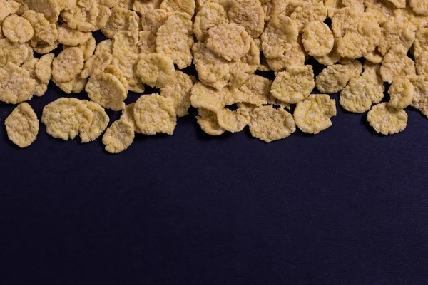 Corn flakes on a black background top — Stock Photo, Image