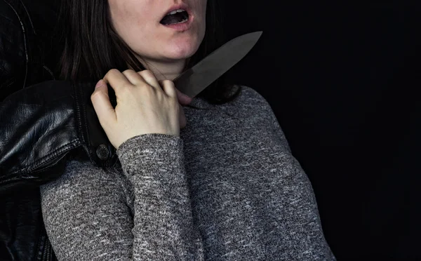 Ember, aki egy késsel, a lány torkát, fekete háttér — Stock Fotó