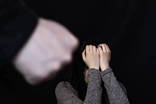 泣いている女の子の背景に黒の背景に男性の拳 — ストック写真