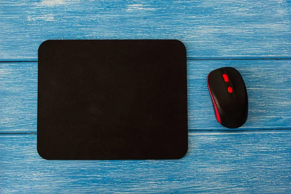 computer mouse pad and mouse on a blue wooden background