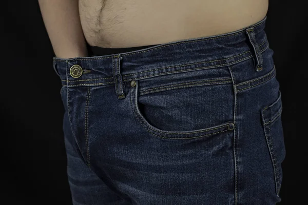 O homem colocou a mão em suas calcinhas, fundo preto, close-up — Fotografia de Stock