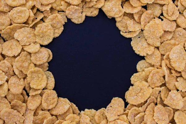 Cornflakes auf schwarzem Hintergrund — Stockfoto