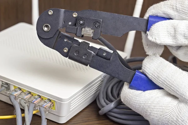 A man is squeezing a chip on a network cable, a modem, the Internet, a close-up — Stock Photo, Image