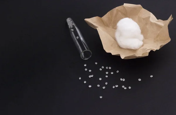 A medical test-tube, granules-tablets and cotton-wool on a black background — Stock Photo, Image