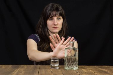 Sarhoş kız masada, el durak, siyah arka plan, masanın üstüne alkol gösterir yatıyor