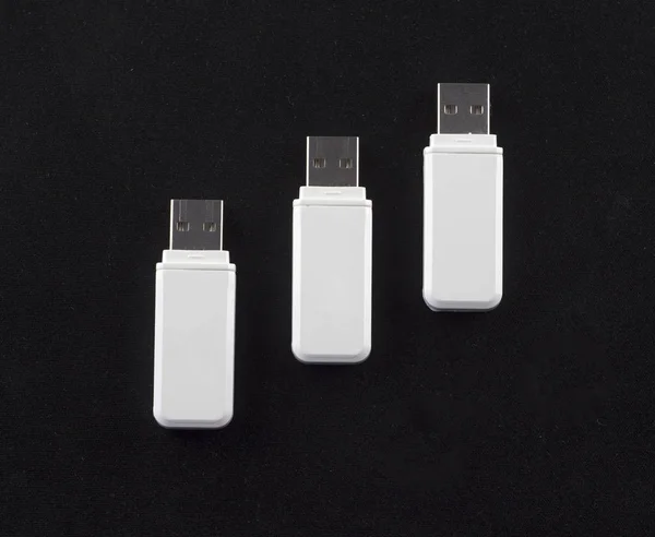 three white flash drives on a black background