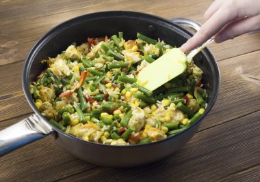 Bir kızartma tavası ahşap arka planda haşlanmış sebze