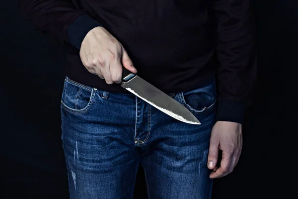 Человек с ножом на черном фоне, средний план — стоковое фото