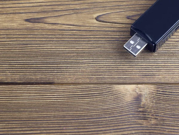 Black USB flash drive on a wooden background