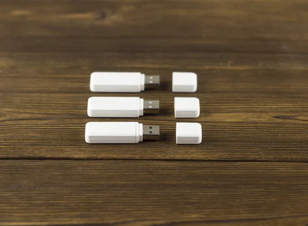 Trzy białe dyski flash Usb na podłoże drewniane — Zdjęcie stockowe