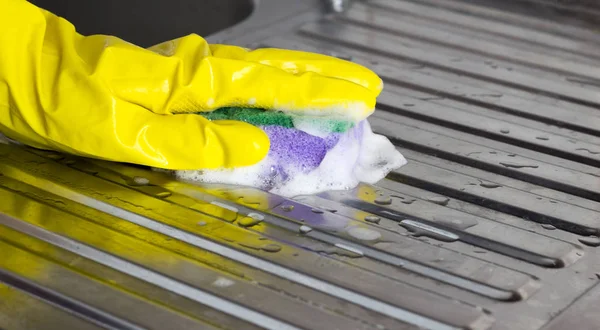 Мыть раковину на кухне в жёлтых перчатках, крупным планом — стоковое фото