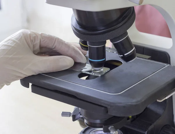Microscopio de análisis de sangre, mano, guante, primer plano — Foto de Stock