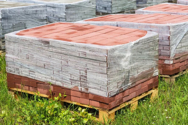 Red paving slab on pallets, red paving brick