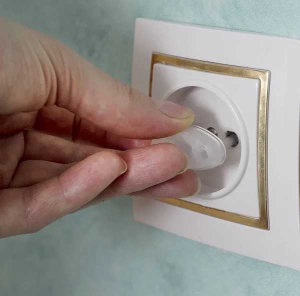 The girl inserts the plug into the socket from the children, close-up — Stock Photo, Image