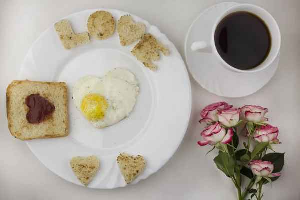 Desayuno para los amantes, huevos revueltos, café, rosas — Foto de Stock