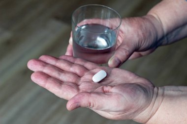 Yaşlı kadın, yakın çekim tablet el ve bardak su,