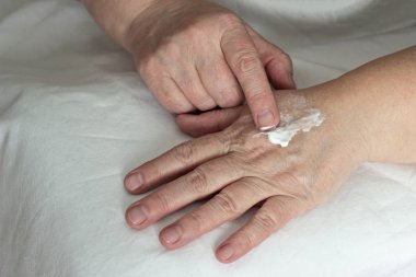 sürtünme el kremi, beyaz arka plan, yakın çekim yaşlı kadın