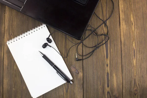 Notebook headphones caneta bloco de notas sobre a mesa de madeira — Fotografia de Stock