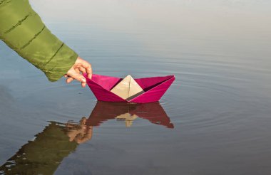 Kız bir kırmızı kağıt tekne, yakın çekim başlatıyor